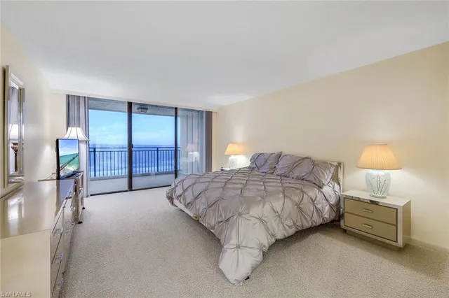 a spacious bedroom with a bed and a night stand