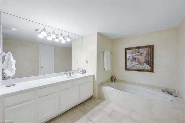 a spacious bathroom with a double vanity sink mirror and bathtub