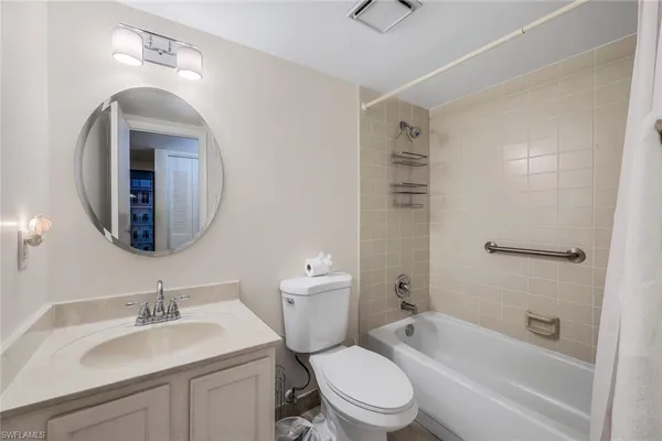 a bathroom with a toilet a sink a mirror and bathtub