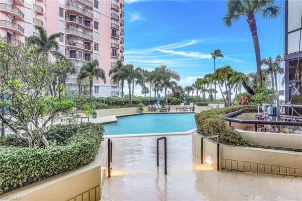 a view of swimming pool with outdoor seating and lake view