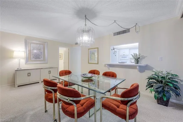 a dining room with furniture a potted plant and a chandelier