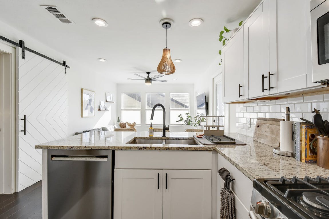 2901 Glen Rae Street, Unit A Austin, TX 78702 - Photo 2 of 36 a kitchen with kitchen island granite countertop a sink stainless steel appliances and cabinets