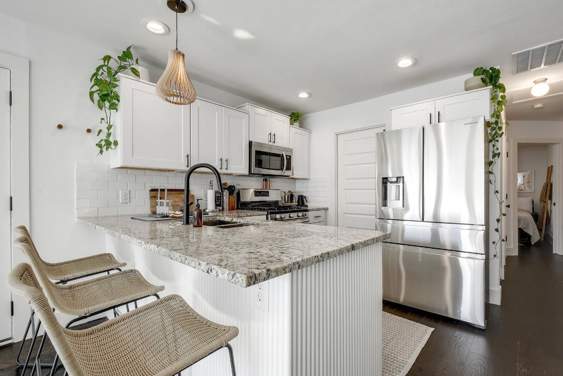 2901 Glen Rae Street, Unit A Austin, TX 78702 - Photo 9 of 36 a kitchen with kitchen island granite countertop a sink a counter space appliances and cabinets