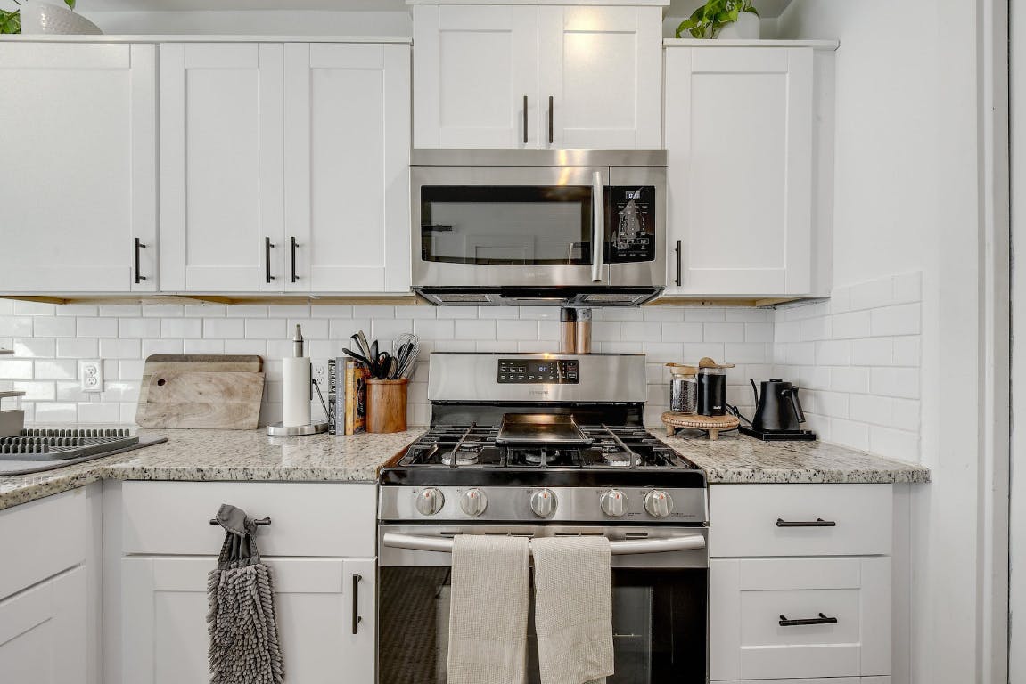 2901 Glen Rae Street, Unit A Austin, TX 78702 - Photo 10 of 36 a kitchen with granite countertop white cabinets and stainless steel appliances