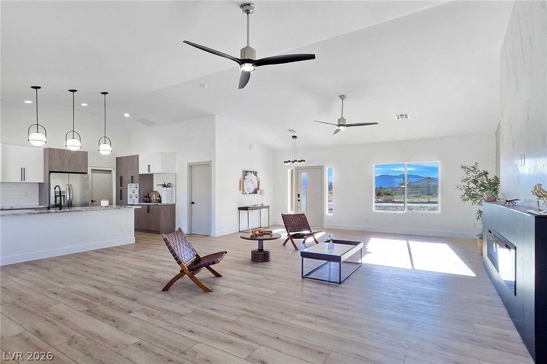 1120 West Gamebird Road Pahrump, NV 89048 - Photo 10 of 36 Living area with high vaulted ceiling, light wood-style floors, and ceiling fan
