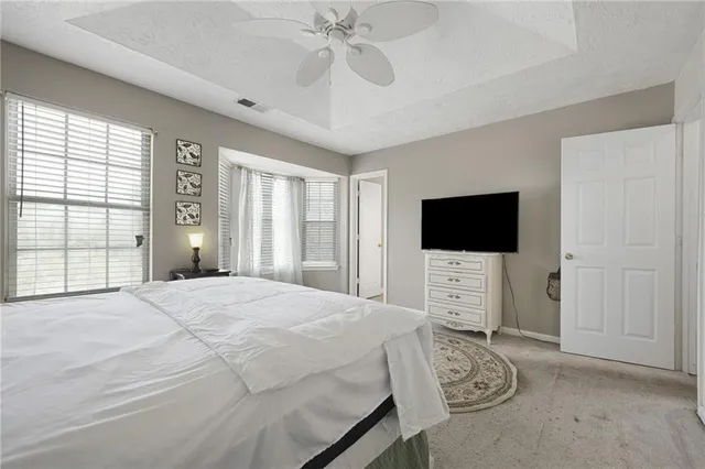 a bedroom with a bed a window and a flat screen tv