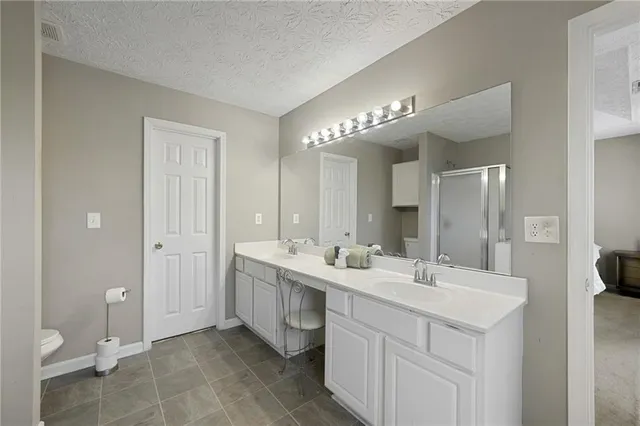 a bathroom with a double vanity sink mirror and toilet