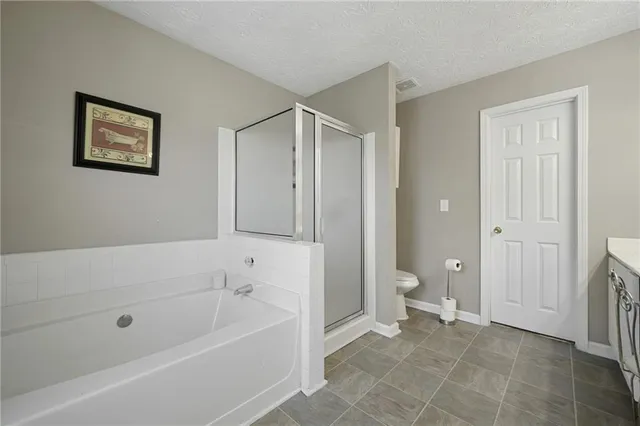 a bathroom with a granite countertop toilet a sink and bathtub