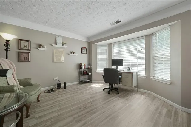 a view of a workspace with furniture and a window