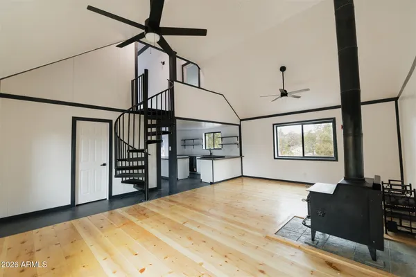 a kitchen with stainless steel appliances a stove a sink a chimney and a refrigerator with wooden floor