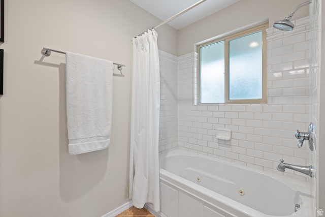 3320 Cherokee Lane Provo, UT 84604 - Photo 24 of 52 Bathtub and shower combination featuring white subway tile surround, polished chrome fixtures, a jetted tub, and a frosted window