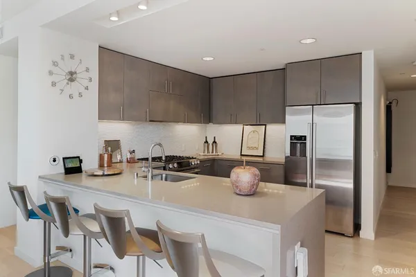 a kitchen with a sink a stove and chairs
