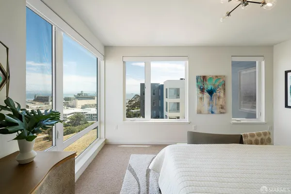 a bedroom with a large window and flowers