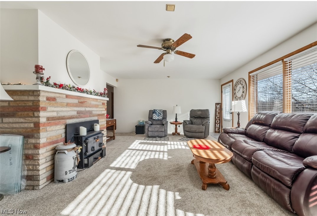 22814 Buck Road Alliance, OH 44601 - Photo 11 of 17 Carpeted living room with ceiling fan and a fireplace