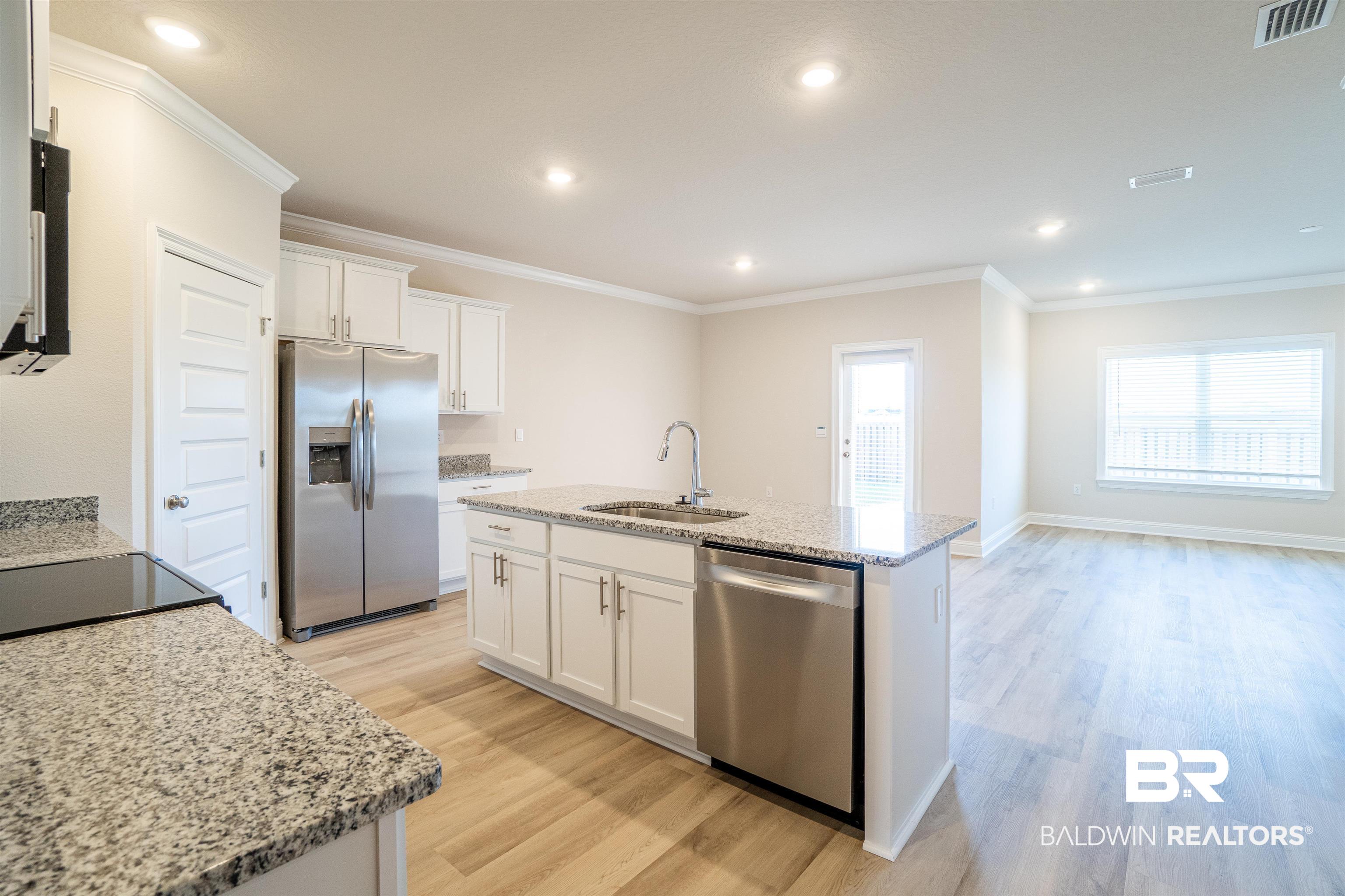 1073 Hayward Loop Foley, AL 36535 - Photo 18 of 18 Modern kitchen featuring a central island with an undermount sink and stainless steel dishwasher