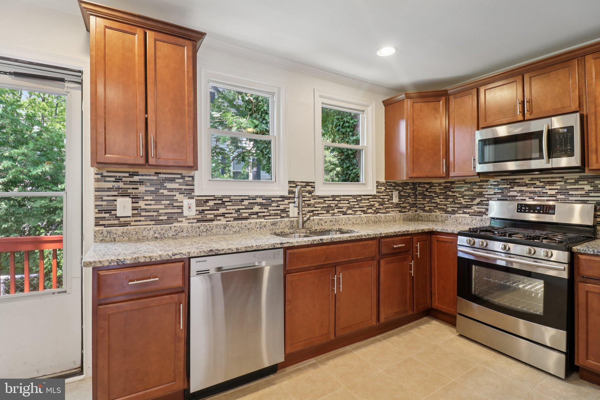 4604 Morgan Road Suitland, MD 20746 - Photo 11 of 38 a kitchen with stainless steel appliances granite countertop a stove sink and microwave