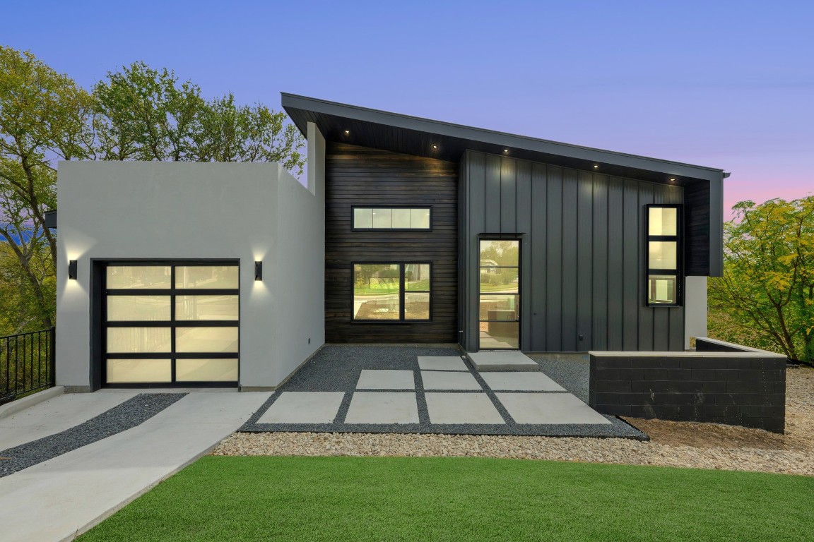 View of front of house with an attached garage, a patio area, and board and batten siding
