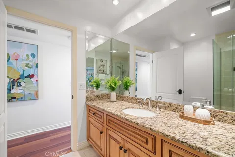 a bathroom with a granite countertop sink a large mirror and a shower