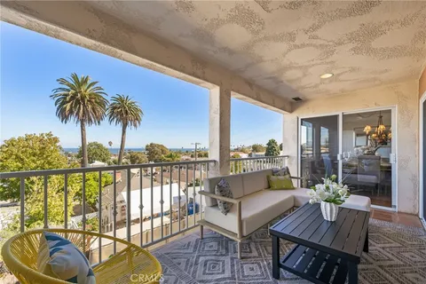 a view of a balcony with furniture and floor to ceiling window