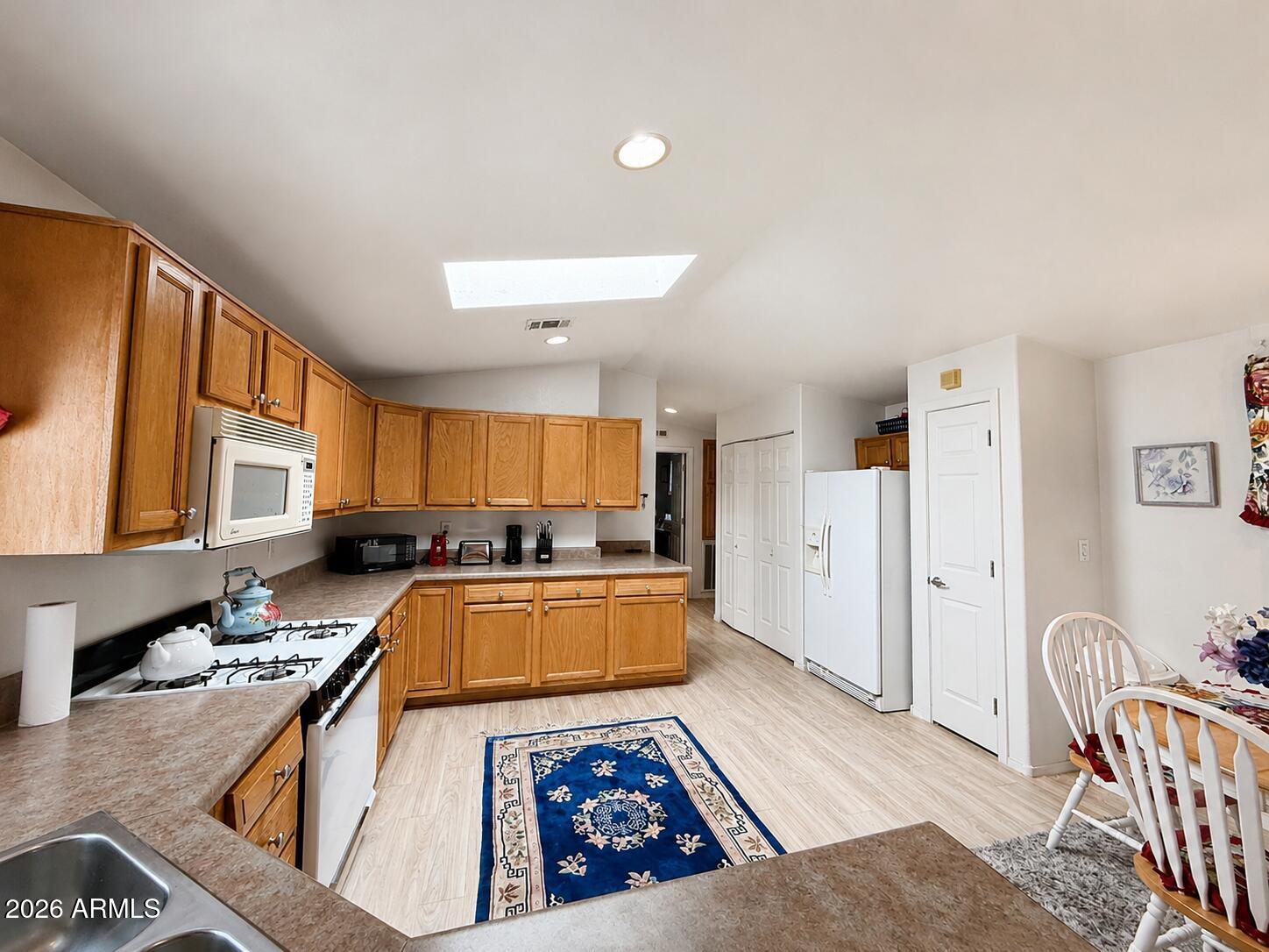 201 South Greenfield Road, Unit 11 Mesa, AZ 85206 - Photo 11 of 22 a kitchen with granite countertop a stove a sink a refrigerator wooden cabinets and dining table