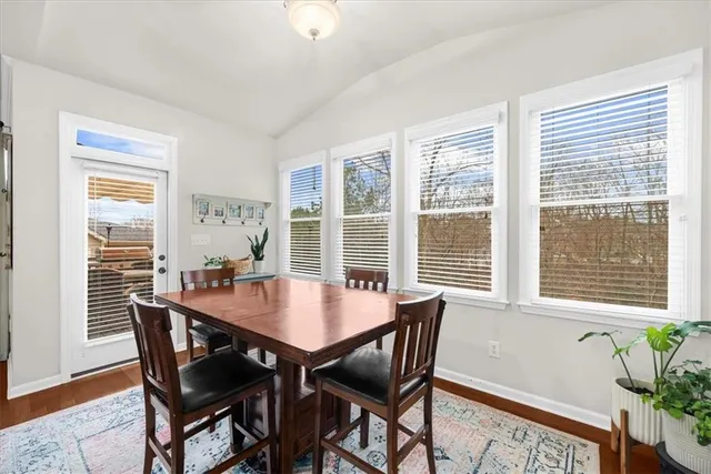 a kitchen with stainless steel appliances granite countertop a sink a stove a dining table and chairs