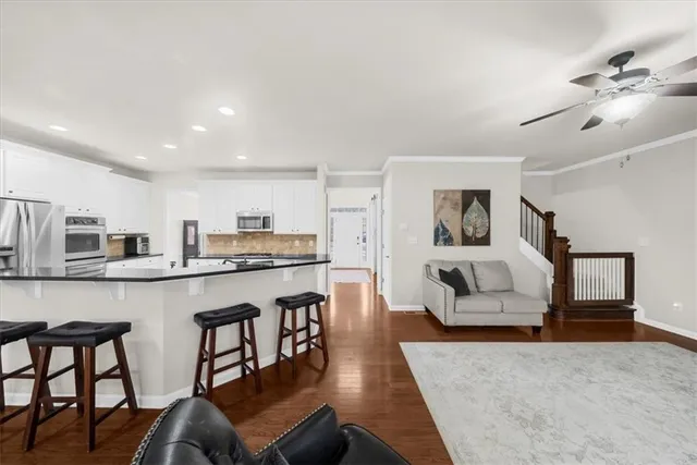 a living room with furniture kitchen area and a window