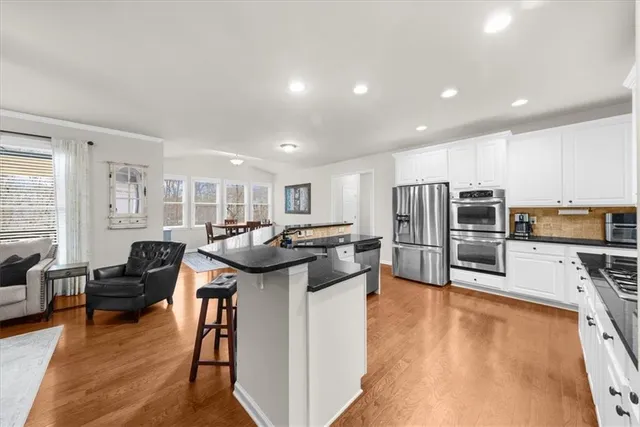 a living room with stainless steel appliances granite countertop furniture and a fireplace
