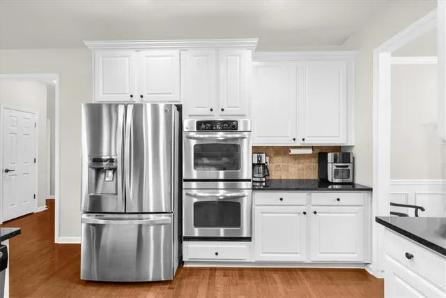 a large kitchen with stainless steel appliances kitchen island granite countertop a sink and cabinets