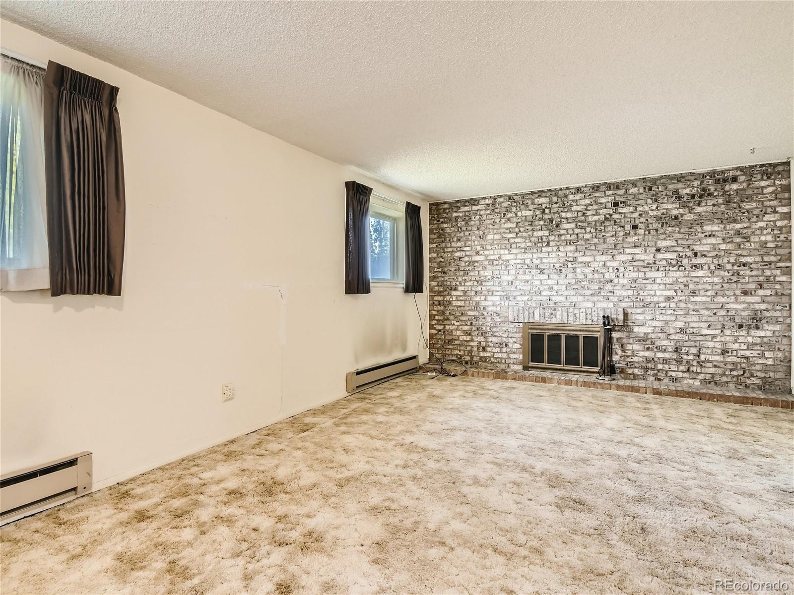 11090 Eudora Way Thornton, CO 80233 - Photo 12 of 28 a view of a livingroom with wooden floor and a fireplace
