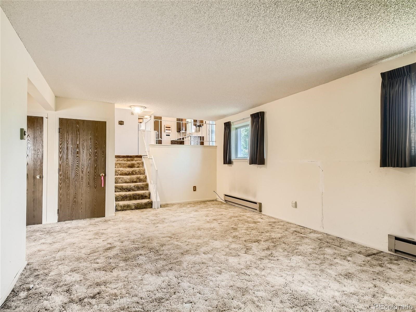 11090 Eudora Way Thornton, CO 80233 - Photo 13 of 28 a view of a livingroom with wooden floor and kitchen space