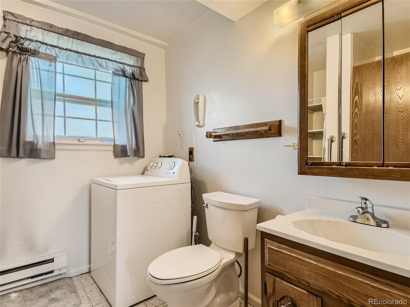 11090 Eudora Way Thornton, CO 80233 - Photo 15 of 28 a bathroom with a sink a toilet and a mirror