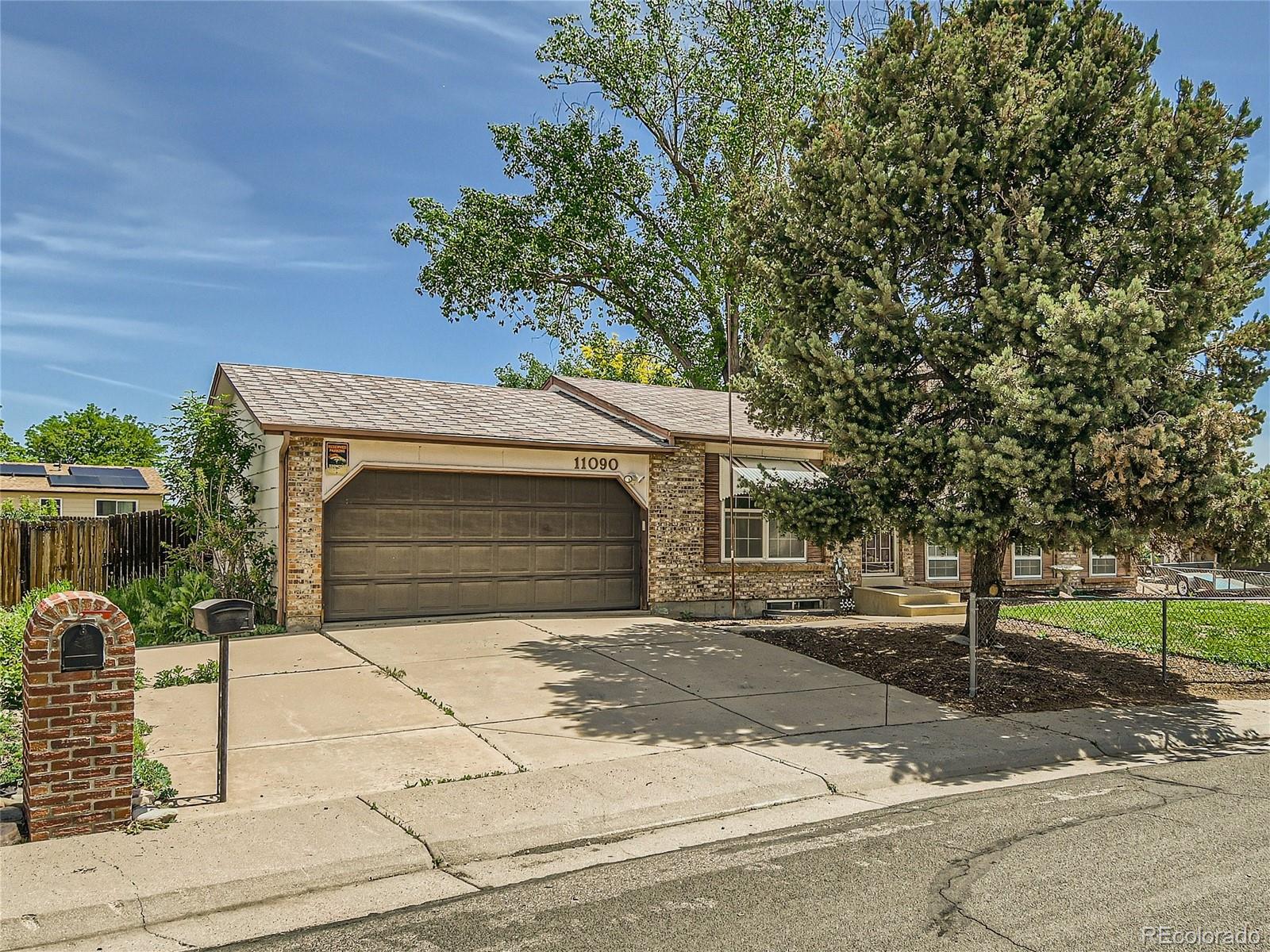 11090 Eudora Way Thornton, CO 80233 - Photo 2 of 28 a front view of a house with a yard and garage