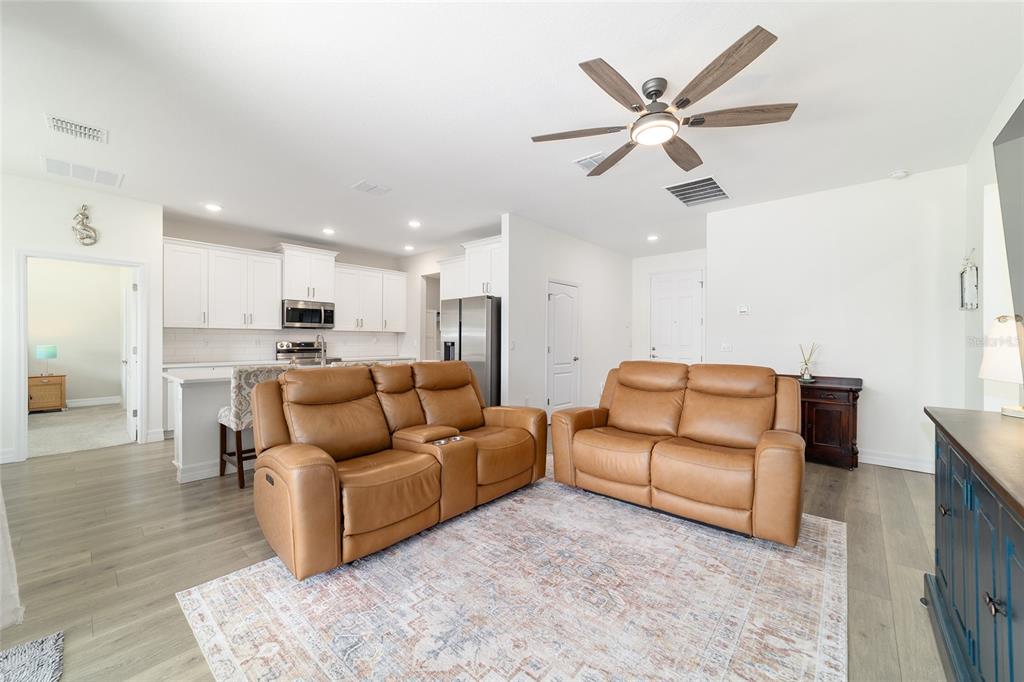 4838 Southwest 130th Street Ocala, FL 34473 - Photo 11 of 48 a living room with furniture kitchen view and a chandelier