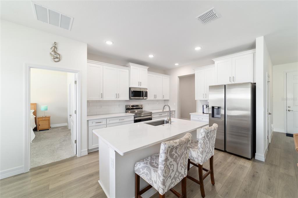 4838 Southwest 130th Street Ocala, FL 34473 - Photo 12 of 48 a kitchen with refrigerator a sink and chairs