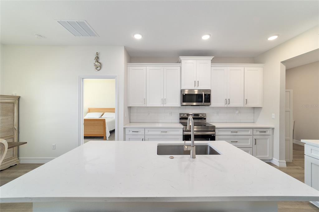 4838 Southwest 130th Street Ocala, FL 34473 - Photo 13 of 48 a kitchen with kitchen island a stove a sink and a refrigerator