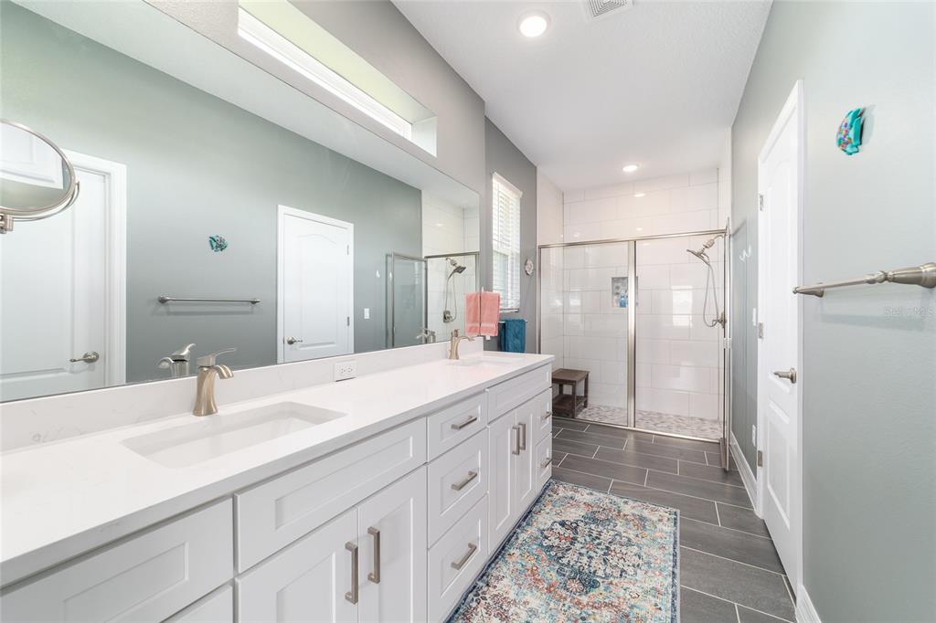 4838 Southwest 130th Street Ocala, FL 34473 - Photo 23 of 48 a spacious bathroom with a double vanity sink a mirror and a shower