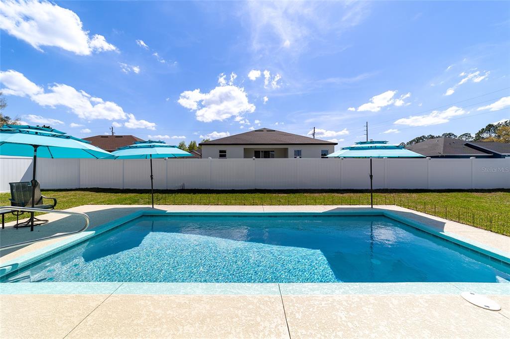 4838 Southwest 130th Street Ocala, FL 34473 - Photo 3 of 48 a view of a swimming pool with an outdoor space and seating area