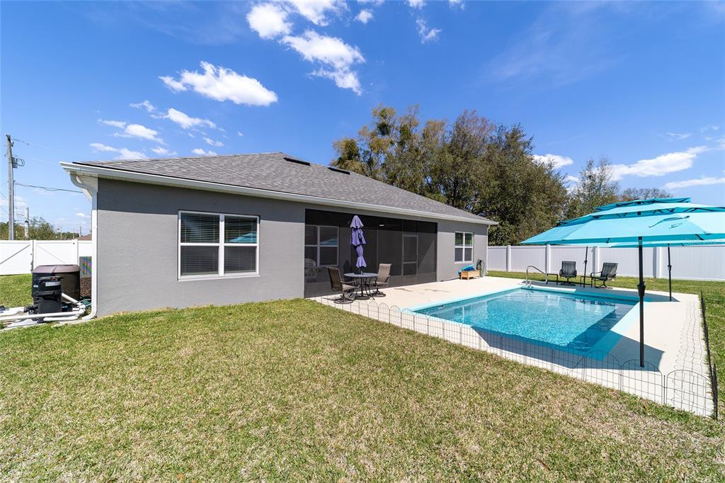 4838 Southwest 130th Street Ocala, FL 34473 - Photo 39 of 48 a view of a house with swimming pool and a yard