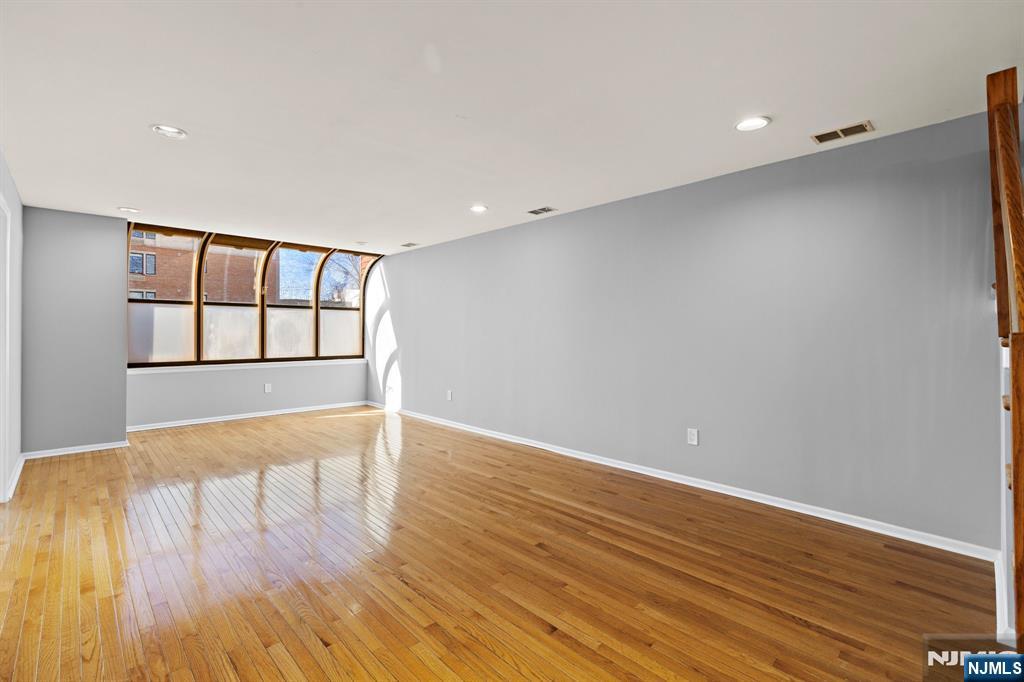 319 Gorge Road, Unit 6 Cliffside Park, NJ 07010 - Photo 3 of 24 a view of an empty room with wooden floor and a window