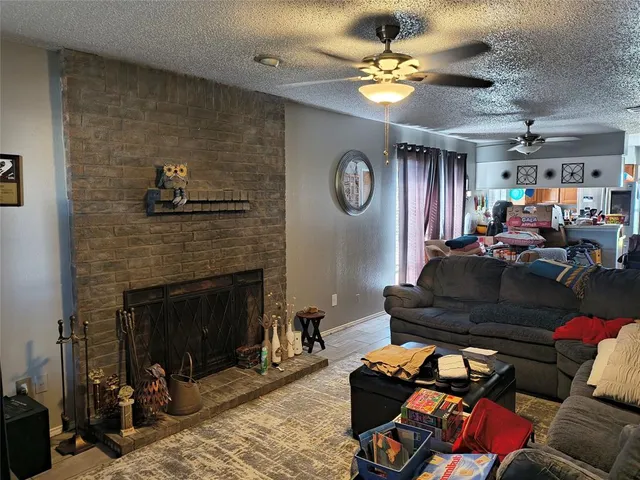 a living room with furniture a fireplace and a ceiling fan