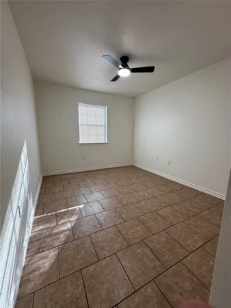an empty room with windows and ceiling fan view