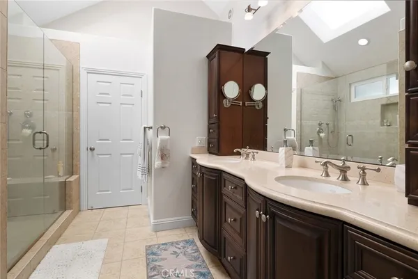 a bathroom with a double vanity sink mirror and shower