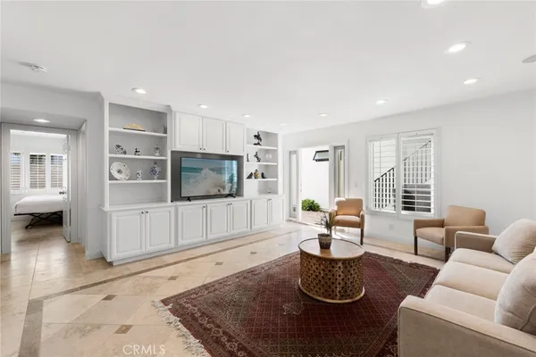 a living room with furniture a flat screen tv and a rug