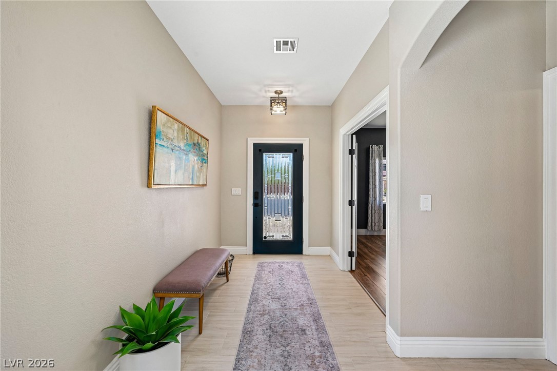 1176 Butternut Ranch Court Henderson, NV 89052 - Photo 4 of 60 A welcoming entry hall features light-toned flooring, a decorative rug, and a front door with elegant glass inserts.