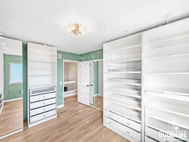 a view of walk in closet with empty racks