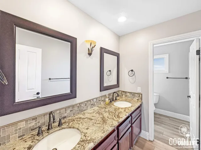 a bathroom with a granite countertop sink and a mirror
