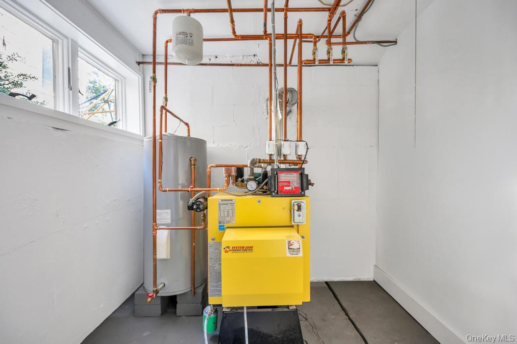 10 South Lot Road Smithtown, NY 11787 - Photo 36 of 50 Basement utility room featuring a yellow boiler system, water heater, and extensive copper piping