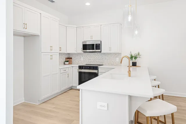 a kitchen with granite countertop white cabinets and white appliances