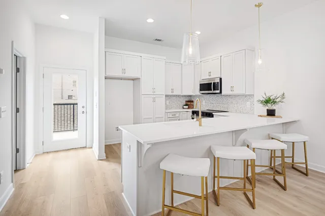 a kitchen with kitchen island white cabinets and stainless steel appliances