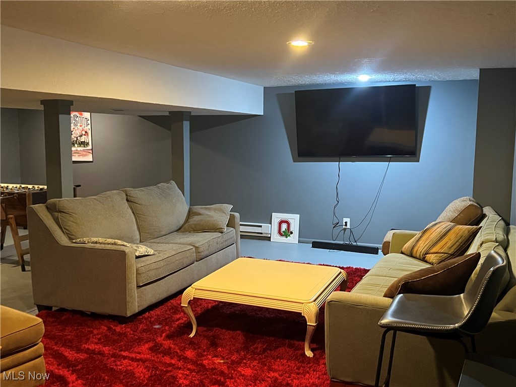 5912 Coen Road Vermilion, OH 44089 - Photo 19 of 28 Living area featuring a textured ceiling and a baseboard heating unit